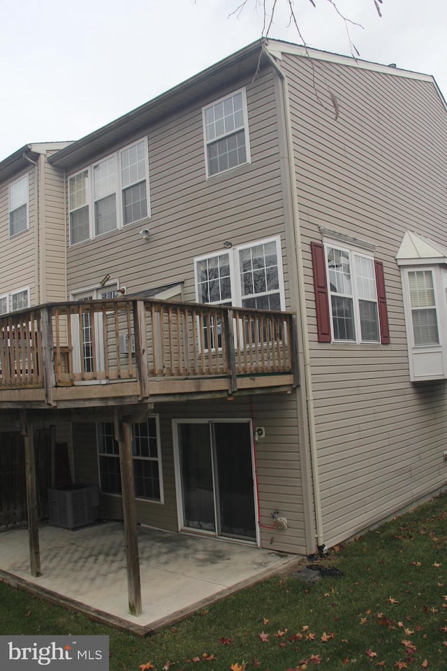 rear view of property featuring a patio, cooling unit, and a wooden deck