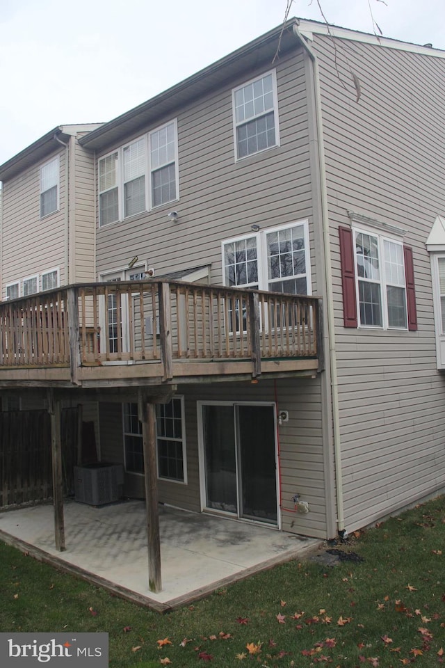 rear view of house featuring a wooden deck and a patio