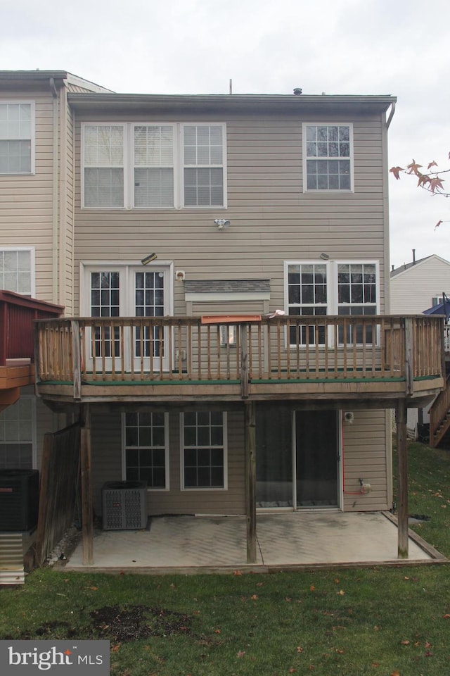 rear view of property with a patio area, a yard, cooling unit, and a wooden deck