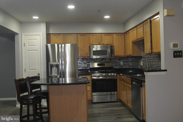 kitchen with decorative backsplash, a kitchen breakfast bar, stainless steel appliances, sink, and dark hardwood / wood-style floors