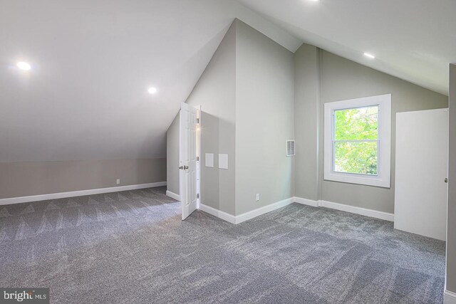 bonus room with carpet floors and vaulted ceiling