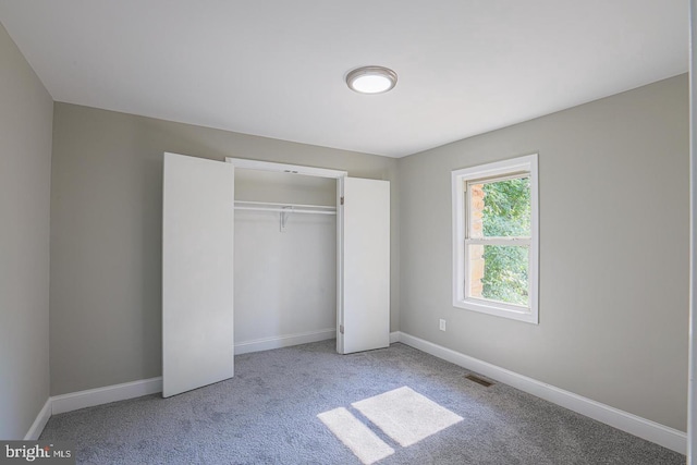 unfurnished bedroom featuring carpet floors and a closet