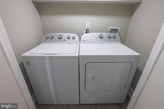 laundry area featuring washer and clothes dryer and dark wood-type flooring