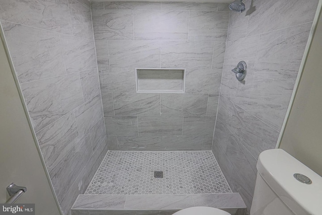 bathroom with toilet and tiled shower