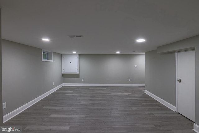 basement with dark hardwood / wood-style flooring