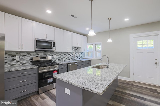 kitchen featuring plenty of natural light, sink, decorative light fixtures, white cabinetry, and stainless steel appliances