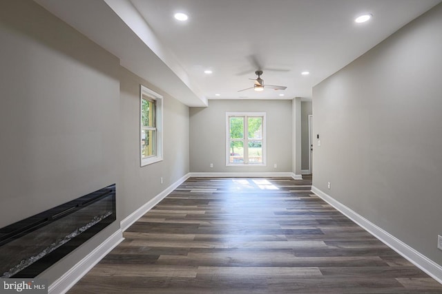 unfurnished living room with ceiling fan and dark hardwood / wood-style flooring