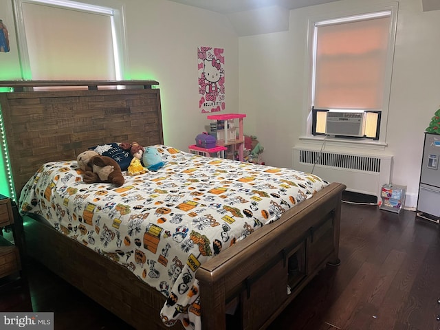 bedroom featuring radiator heating unit, cooling unit, and dark hardwood / wood-style floors