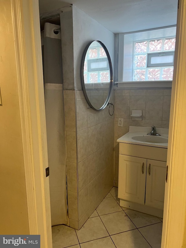 bathroom with tile patterned floors, vanity, and tile walls