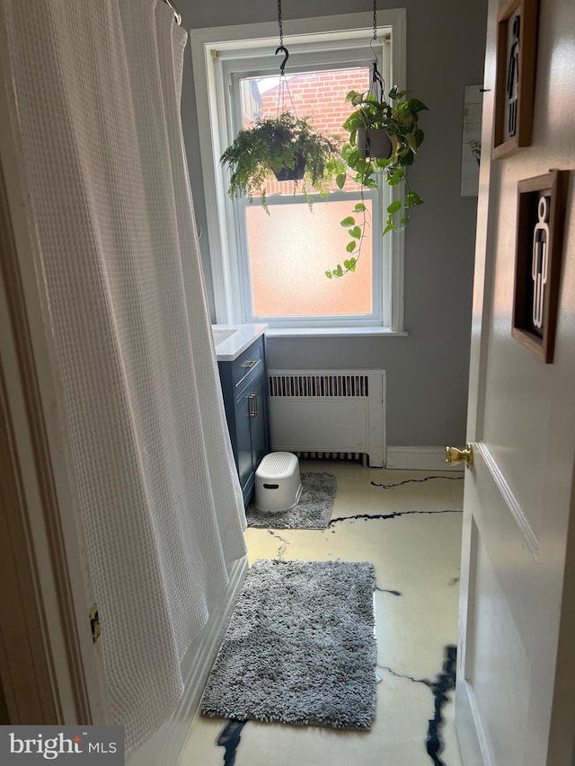 bathroom featuring a wealth of natural light and radiator heating unit