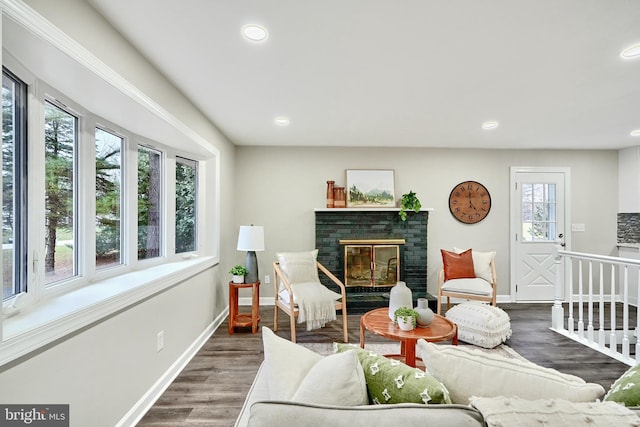 living room featuring dark hardwood / wood-style flooring and a brick fireplace