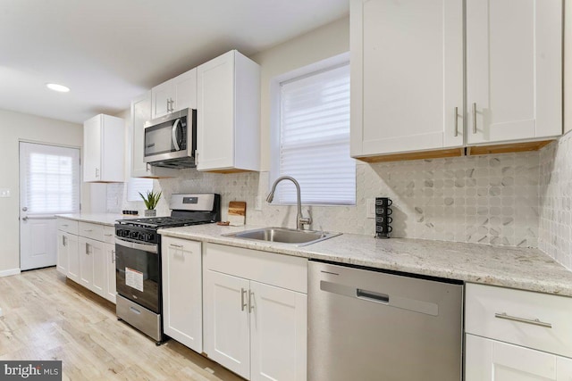 kitchen featuring white cabinets, light hardwood / wood-style floors, sink, and appliances with stainless steel finishes