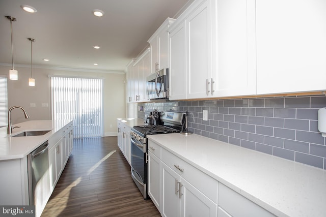 kitchen with sink, white cabinetry, backsplash, hanging light fixtures, and stainless steel appliances