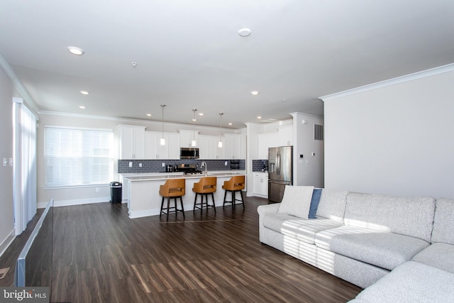 living room featuring dark hardwood / wood-style flooring, sink, and crown molding