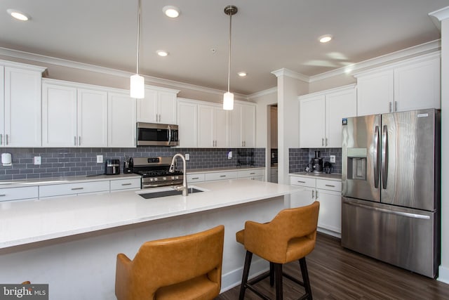 kitchen featuring stainless steel appliances, white cabinets, and decorative light fixtures