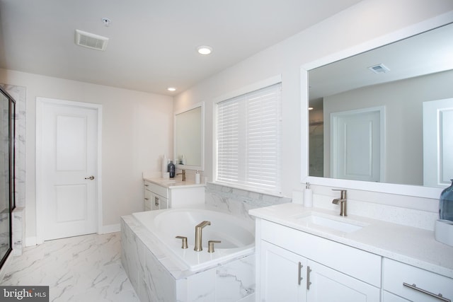 bathroom with vanity and tiled bath