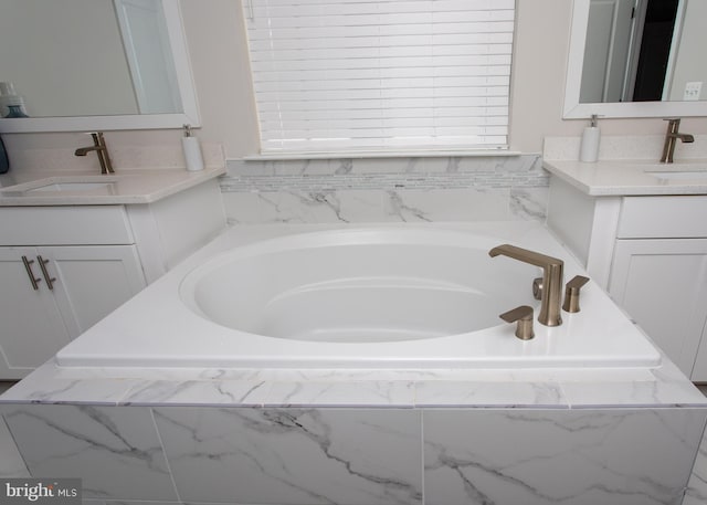 bathroom with vanity and a relaxing tiled tub