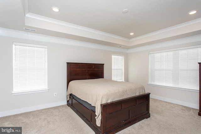 bedroom featuring crown molding, a tray ceiling, and light colored carpet