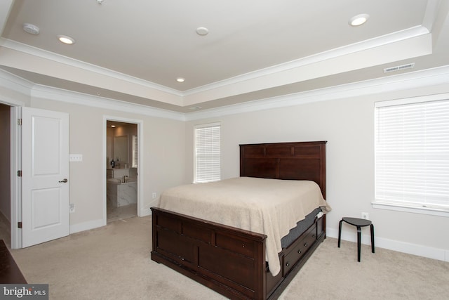 carpeted bedroom with crown molding, ensuite bath, and a raised ceiling