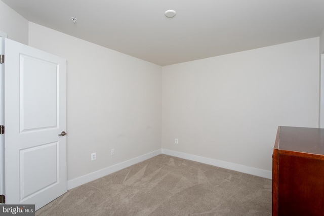 unfurnished room featuring light carpet