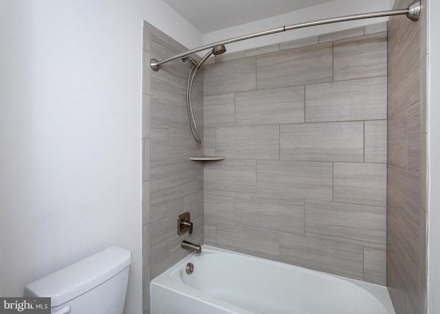 bathroom featuring tiled shower / bath and toilet