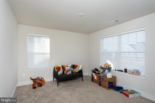 living area featuring plenty of natural light and light colored carpet