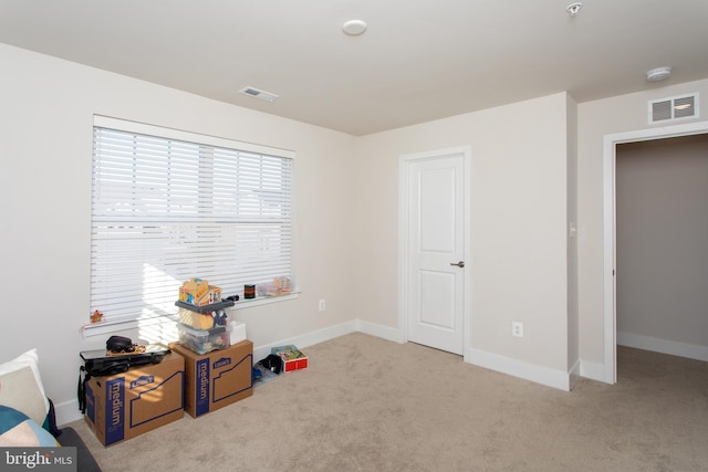 miscellaneous room featuring light colored carpet