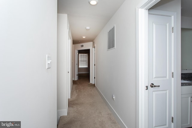 hall featuring light colored carpet