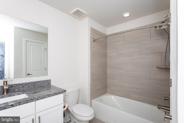 full bathroom with vanity, tiled shower / bath combo, and toilet