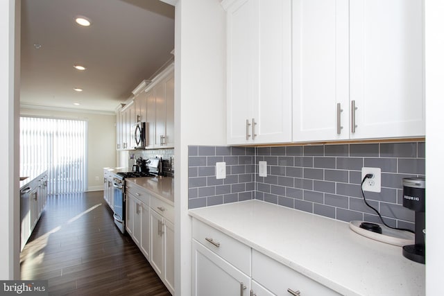 kitchen featuring white cabinetry, backsplash, stainless steel appliances, and dark hardwood / wood-style floors