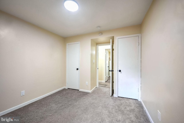 unfurnished bedroom featuring light carpet