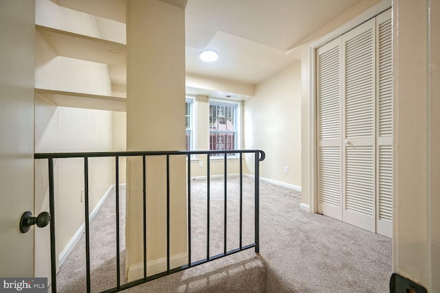 hallway featuring light colored carpet