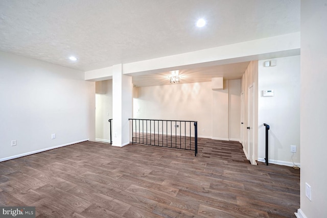 basement with a textured ceiling and dark hardwood / wood-style floors