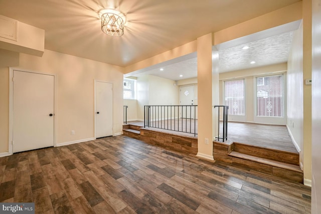 additional living space with dark wood-type flooring and a textured ceiling