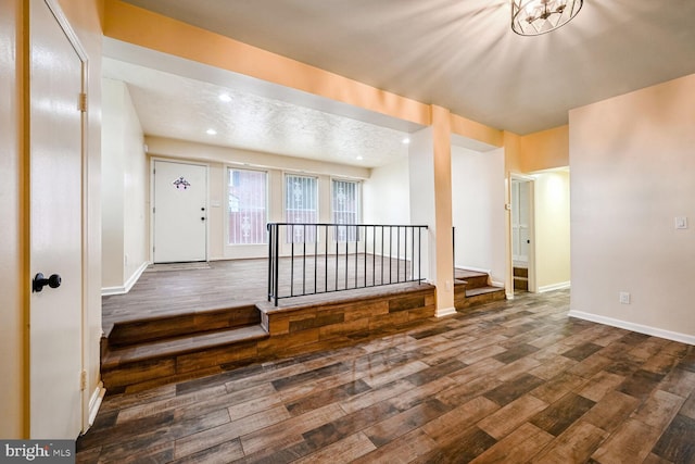 foyer entrance featuring a textured ceiling and dark hardwood / wood-style floors