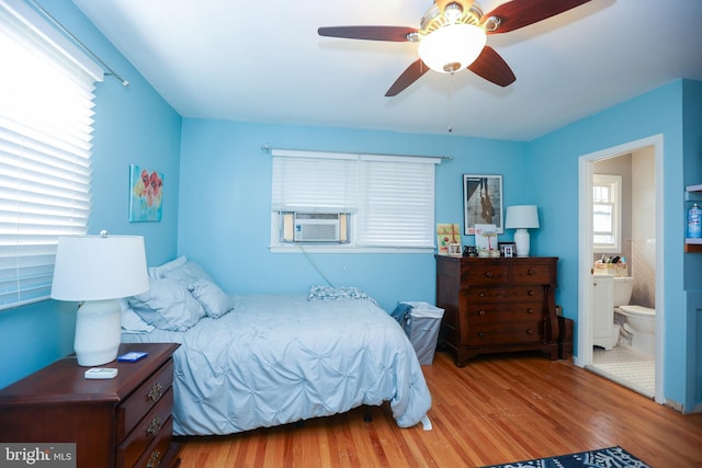 bedroom featuring light wood-type flooring, ceiling fan, cooling unit, and connected bathroom