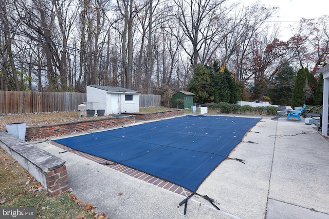 view of pool featuring a storage unit and a patio area