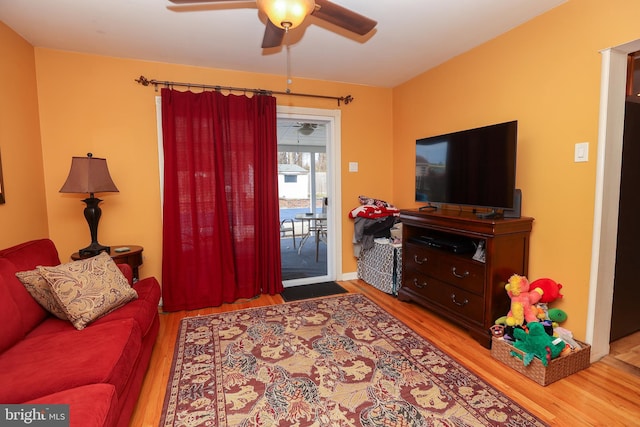 living room featuring hardwood / wood-style floors and ceiling fan