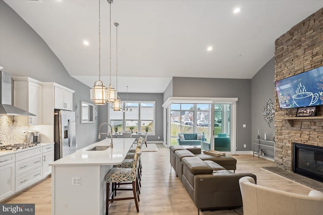 kitchen featuring white cabinetry, sink, pendant lighting, a kitchen island with sink, and appliances with stainless steel finishes