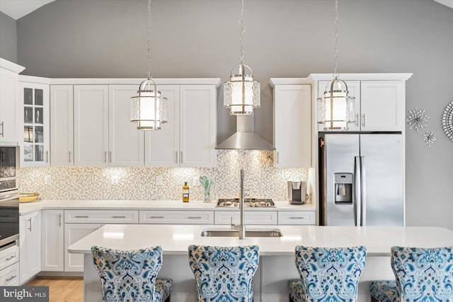 kitchen featuring pendant lighting, backsplash, white cabinetry, and stainless steel appliances