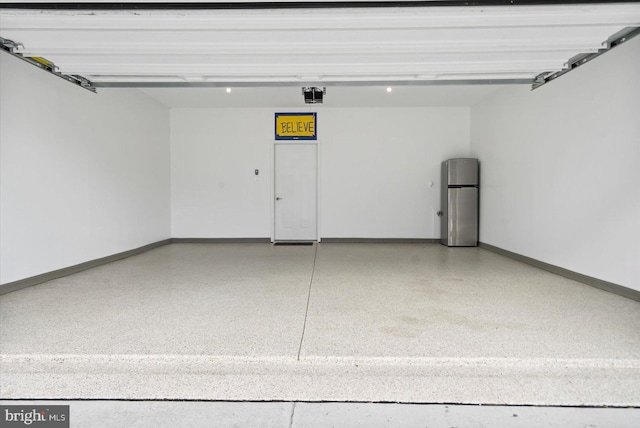 garage featuring stainless steel fridge and a garage door opener