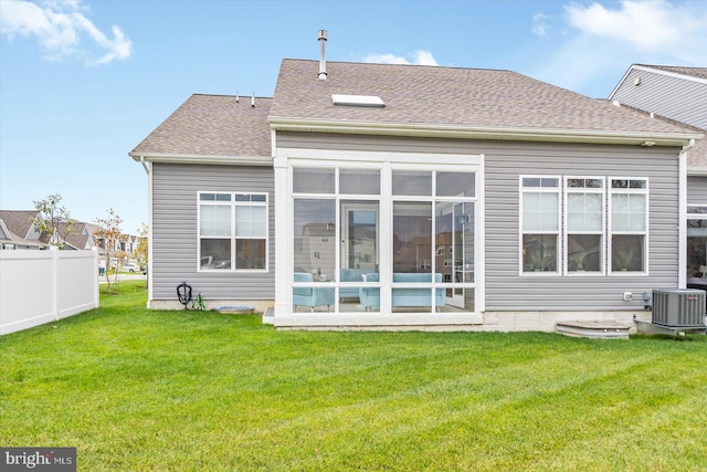 back of house with a sunroom, a yard, and central AC unit