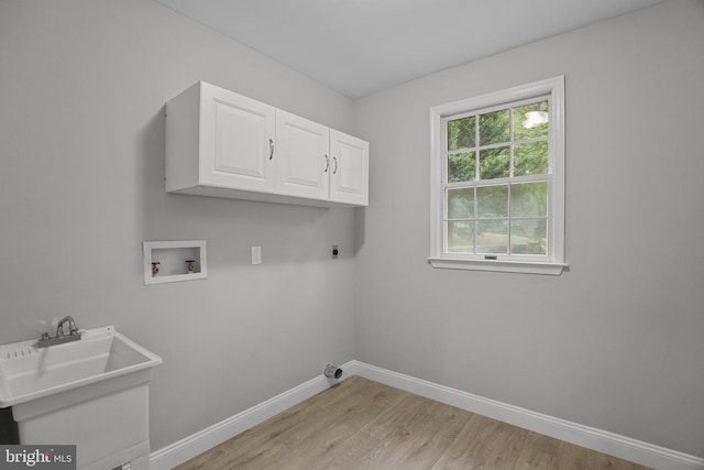 laundry room featuring sink, cabinets, washer hookup, hookup for an electric dryer, and light hardwood / wood-style flooring