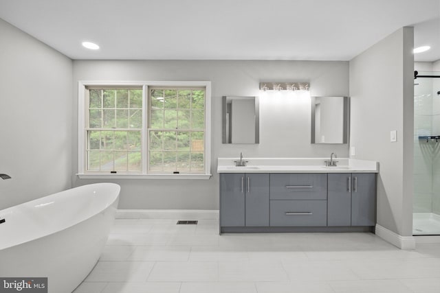 bathroom featuring vanity and independent shower and bath