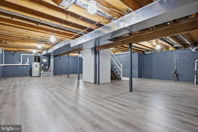 basement with heating unit, wood-type flooring, and water heater