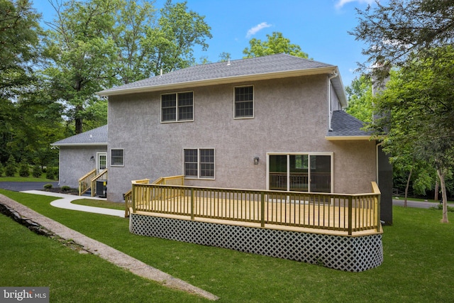 rear view of house with a deck and a lawn