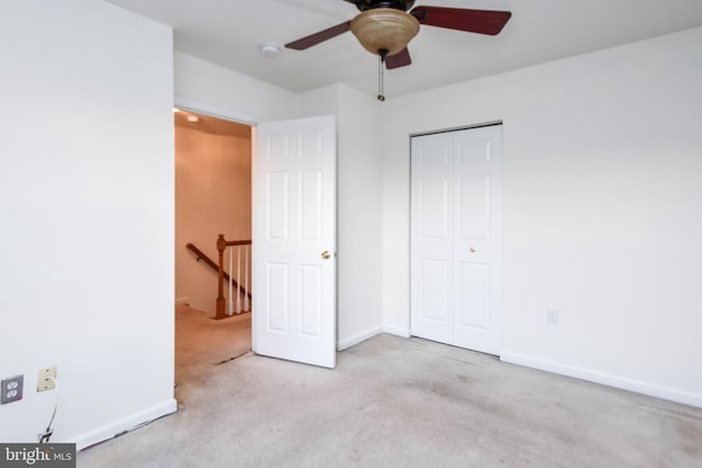 unfurnished bedroom with ceiling fan, light carpet, and a closet