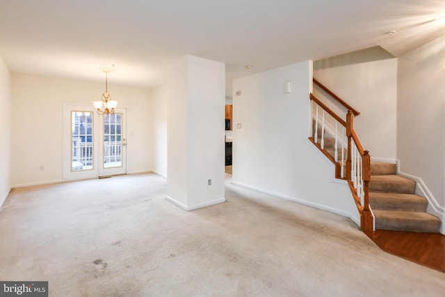 unfurnished living room featuring light colored carpet and a chandelier