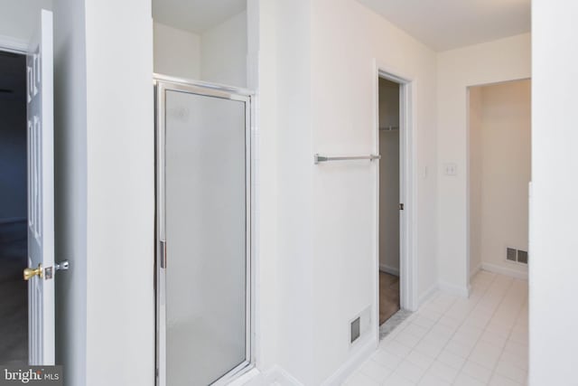 bathroom featuring a shower with door and tile patterned flooring