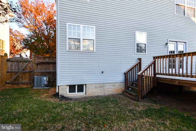 rear view of house featuring a yard, cooling unit, and a deck